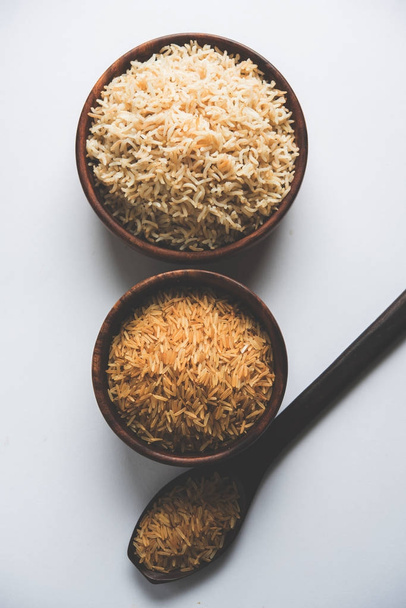 Stock Fotó az indiai barna teljes kiőrlésű basmati rizs és nyers rizs, szolgált egy tál főtt. szelektív összpontosít - Fotó, kép
