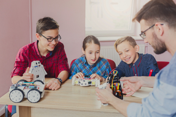 Stem education. Kids creating robots with teacher - Fotoğraf, Görsel