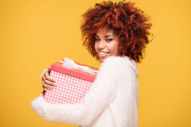 Afro girl posing with gift box, smiling. - Fotografie, Obrázek
