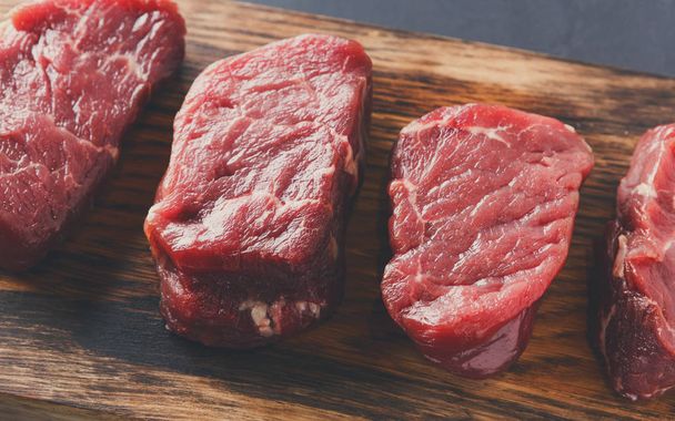 Ham sığır fileto biftek ahşap tahta at gri arka plan üzerinde - Fotoğraf, Görsel