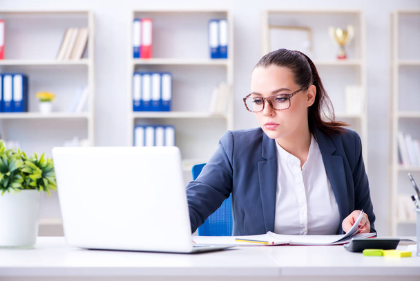 Businesswoman working in the office at desk - Photo, Image
