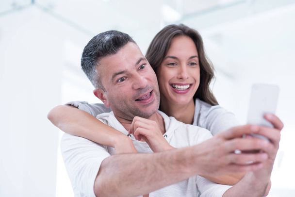 happy couple using mobile phone at home - Foto, Bild
