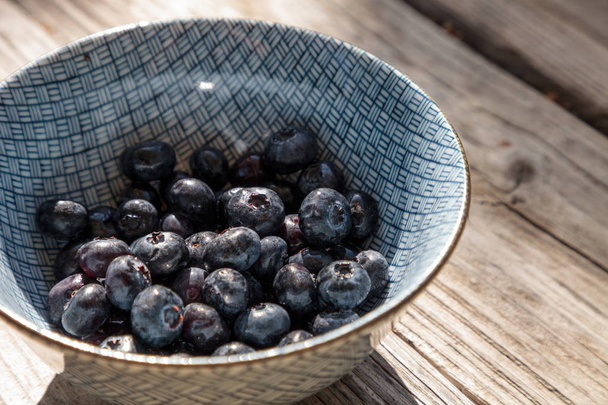 Organiczne jagody w misce niebieski i biały - Zdjęcie, obraz