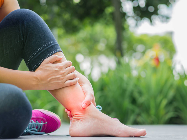 Mujer que sufre de una lesión en el tobillo mientras hace ejercicio
.   - Foto, Imagen