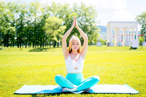Girl doing yoga in a park - 写真・画像