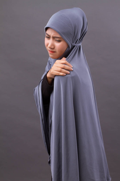 mujer musulmana islámica con dolor de hombro o cuello, rigidez, lesión
 - Foto, imagen