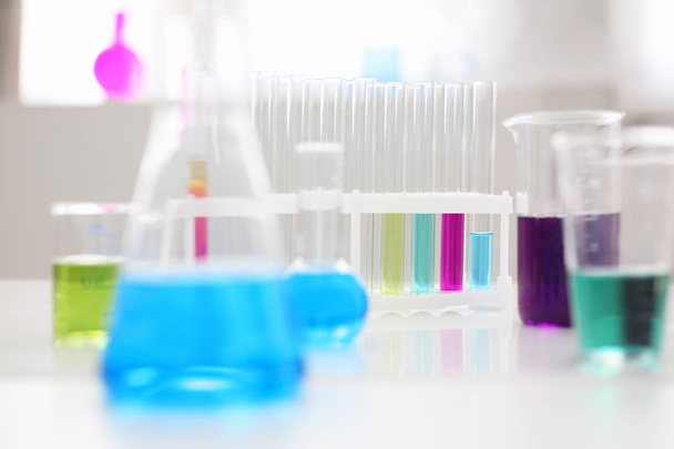 bulbo da indústria química com magenta azul rosa tubos de ensaio líquido estão na mesa
 - Foto, Imagem