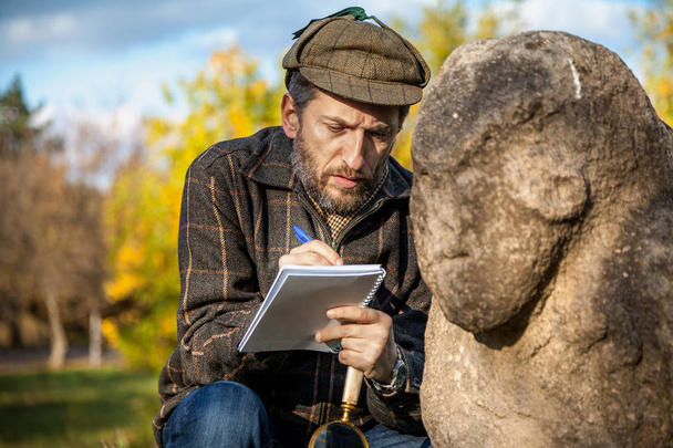scientist and historian, describes sitting stone sculpture on mo - Foto, afbeelding