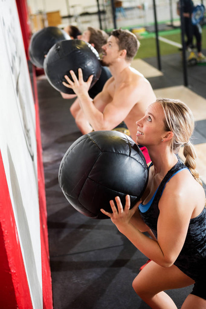 Man And Woman Throwing Medicine Ball In Gym - Фото, изображение