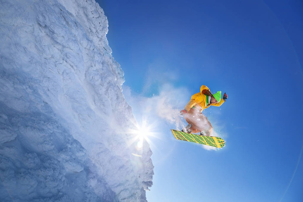 Snowboarder saltando contra el cielo azul
 - Foto, Imagen