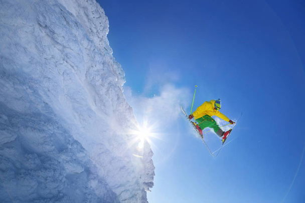 Skifahrer springt gegen blauen Himmel vom Felsen - Foto, Bild