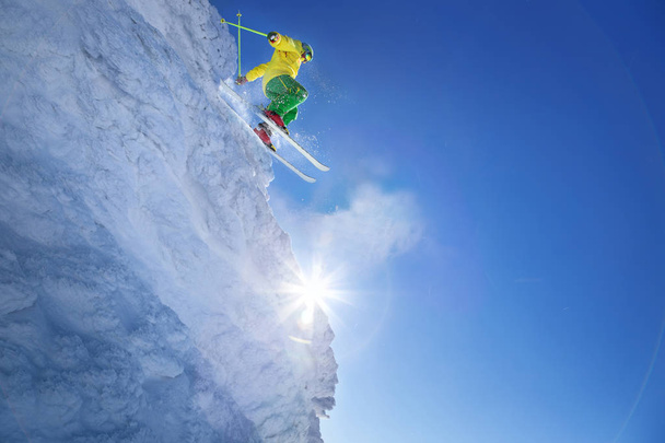 narciarz skoki przeciw błękitne niebo ze skały - Zdjęcie, obraz