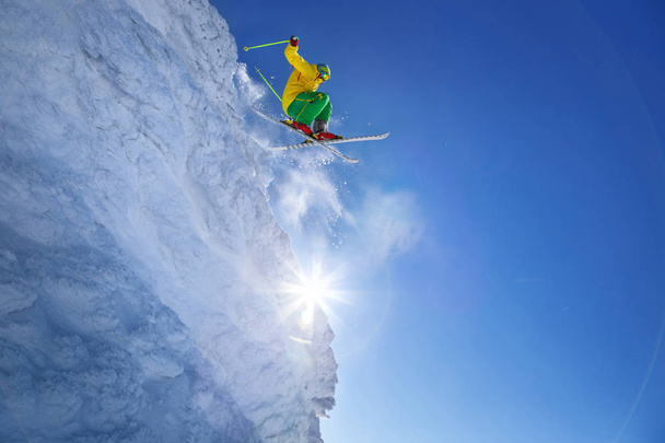 narciarz skoki przeciw błękitne niebo ze skały - Zdjęcie, obraz