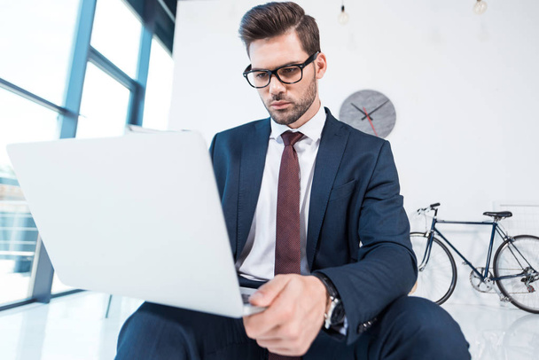 Бизнесмен использует ноутбук в офисе - Фото, изображение