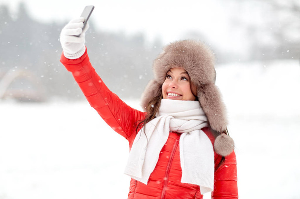 happy woman taking selfie outdoors in winter - Фото, зображення