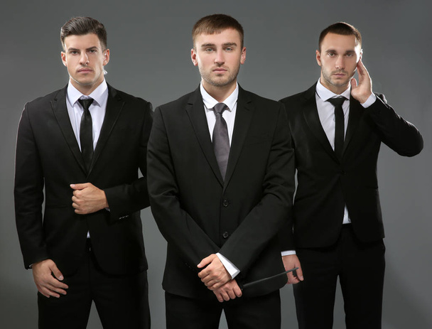 Handsome bodyguards on grey background - Valokuva, kuva