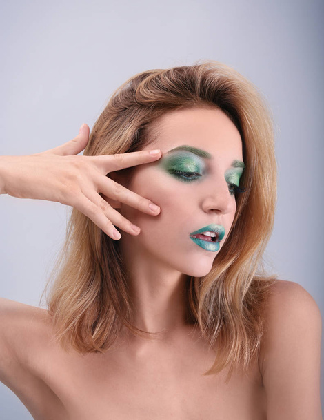 Young woman with bright green makeup  - 写真・画像