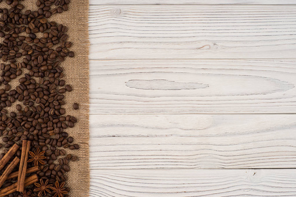 Coffee beans with cinnamon and star anise on an old wooden table - Photo, Image