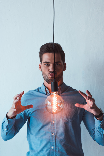 young businessman with light bulb - Foto, Imagen