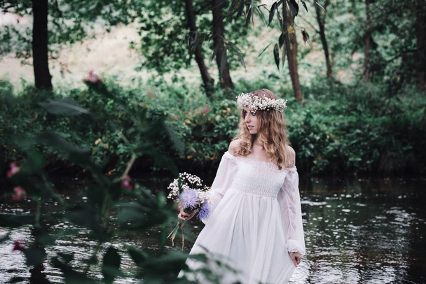 Красива дівчина в білій сукні біля річки
. - Фото, зображення