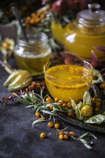 tea with sea buckthorn and honey and autumn leaves - Foto, Imagem