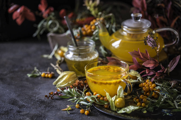 tea with sea buckthorn and honey and autumn leaves - Zdjęcie, obraz