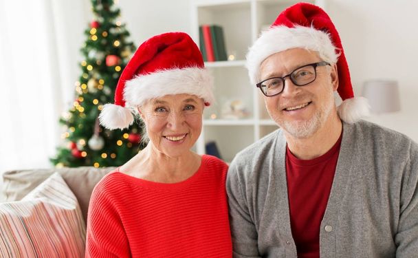 happy senior couple in santa hats at christmas - Fotografie, Obrázek