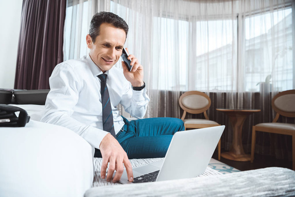 businessman on phone using laptop - Zdjęcie, obraz