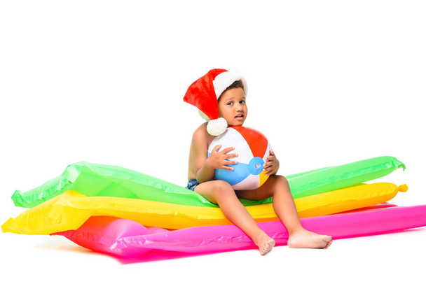 boy in santa hat on swimming mattresses - Foto, afbeelding