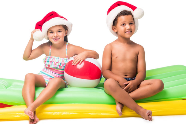 kids in santa hats on swimming mattresses - Photo, Image