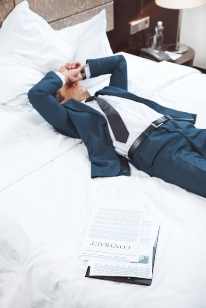 Hombre de negocios agotado acostado en la cama
 - Foto, imagen