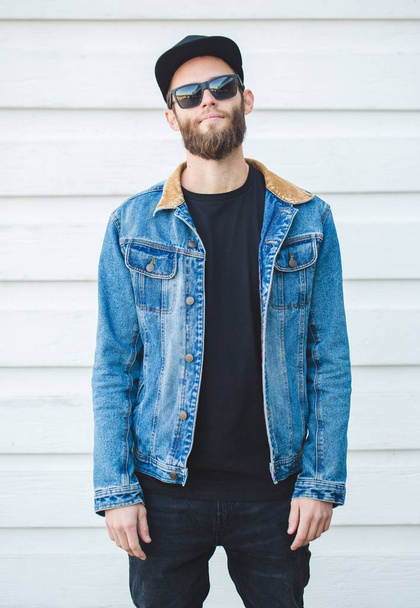 Komea hipster mies hymyilee yllään trendikäs farkut vaatteet
 - Valokuva, kuva