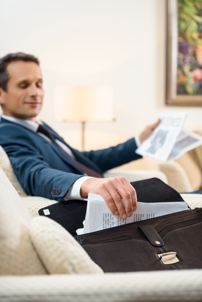Businessman taking paperwork from briefcase - Photo, Image