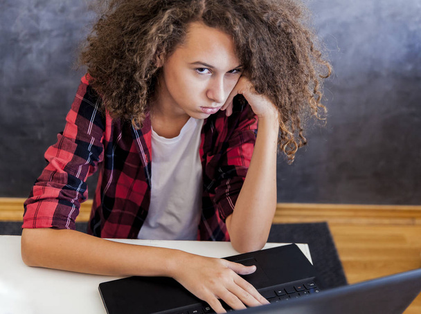 Нещаслива дівчина-підліток використовує ноутбук
 - Фото, зображення