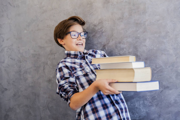 Cute teenage school boy holding books - 写真・画像