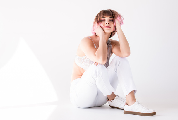 woman with pink hair sitting on floor - Foto, imagen