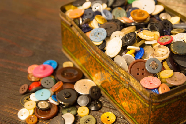 Τα παλιά κουμπιά. Κουμπιά σε ένα παλιό μεταλλικό κουτί. - Φωτογραφία, εικόνα