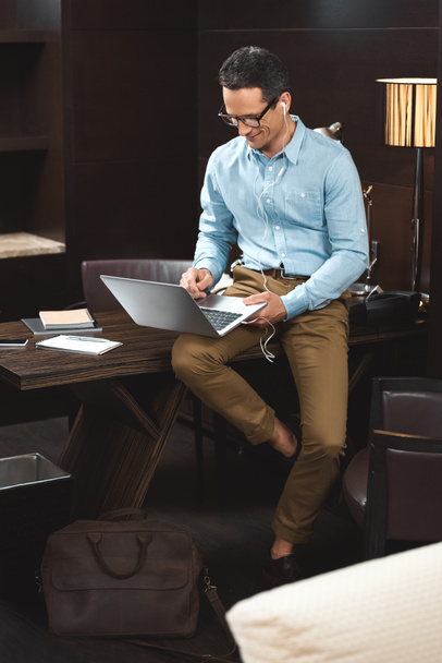 businessman in headphones using laptop - Foto, afbeelding