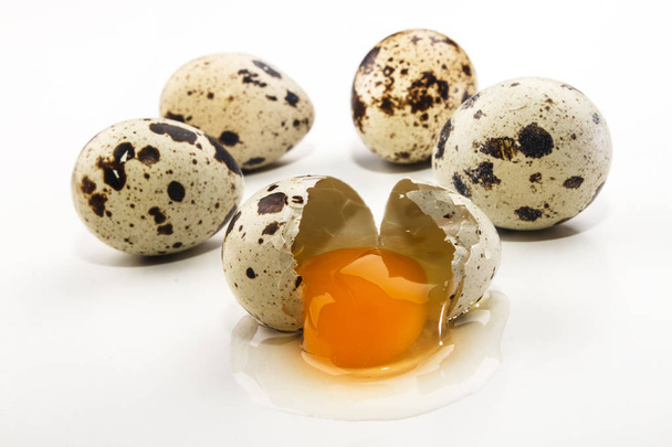 quail eggs and an open egg on bright background - Photo, Image