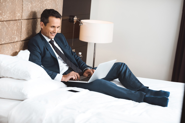 businessman on bed using laptop - Foto, Imagem