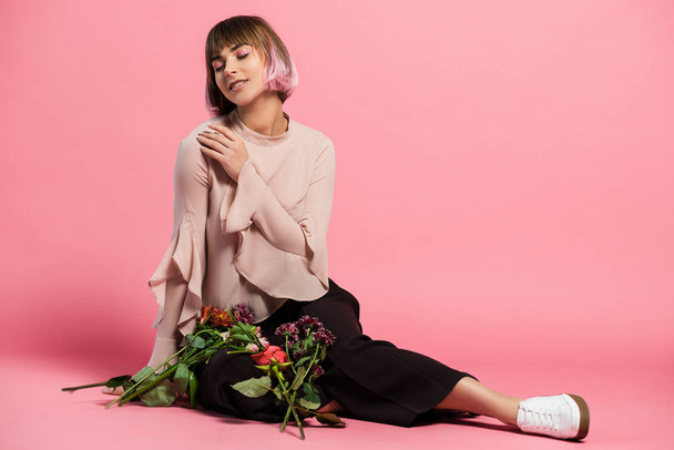 Young woman sitting on floor with bouquet - Photo, Image