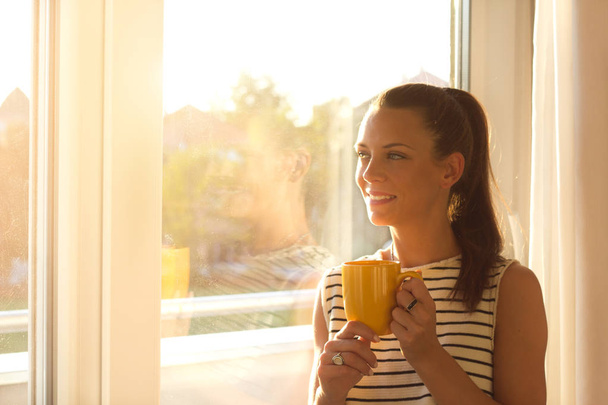 Chica con café al lado de la ventana
 - Foto, Imagen