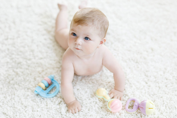Cute baby girl playing with colorful pastel vintage rattle toy - Photo, Image