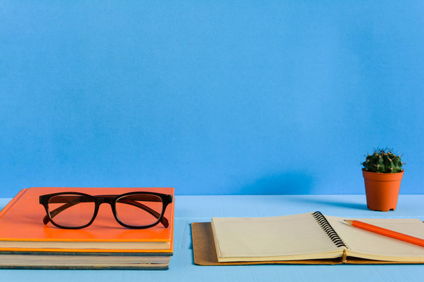 Books Pencil and glasses on a blue wooden table - Photo, Image