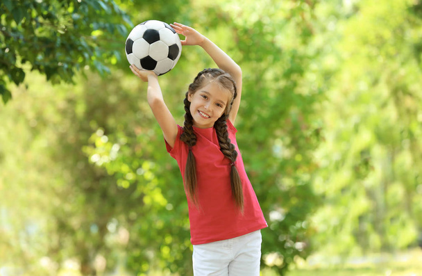 Linda chica con pelota de fútbol en el parque
 - Foto, imagen