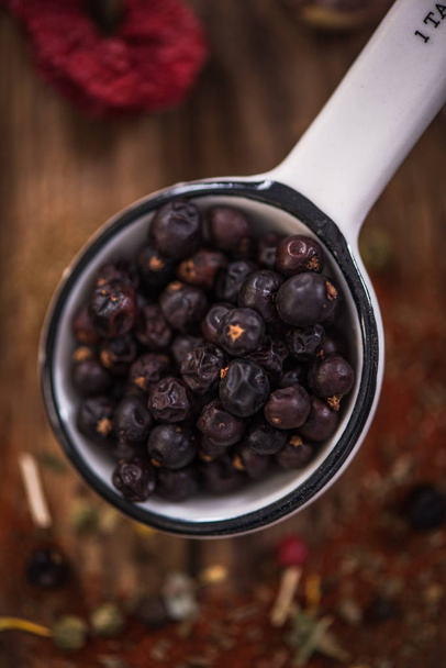 Juniper berry seeds on spoon - Foto, afbeelding