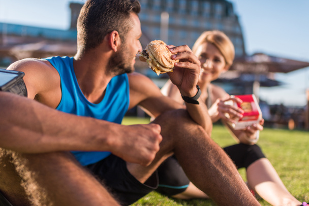 sports couple eating junk food - Photo, Image