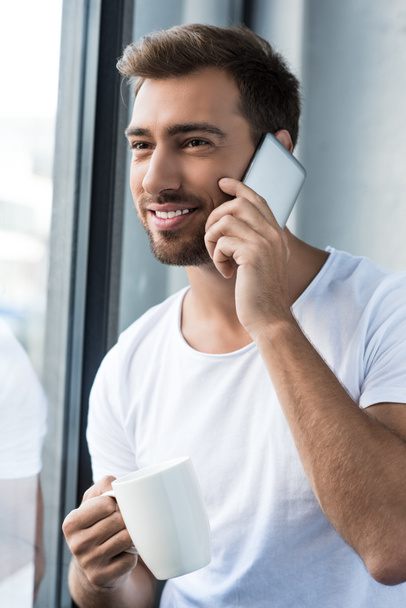 man on phone holding cup of coffee - Photo, image