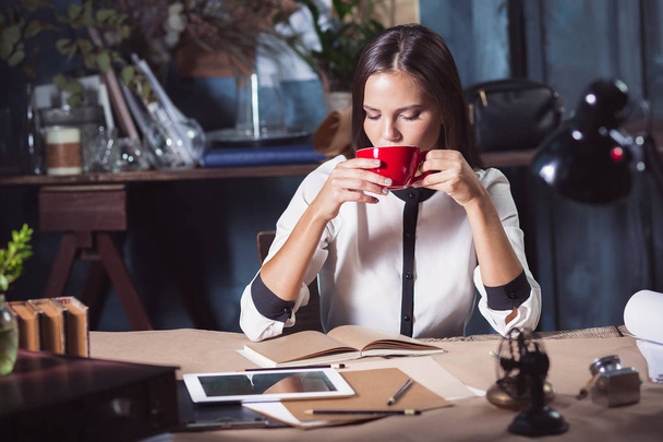 junge schöne Frau arbeitet mit einer Tasse Kaffee - Foto, Bild
