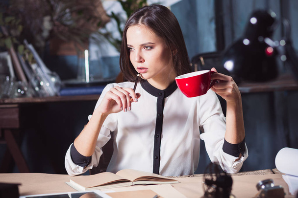 Young beautiful woman working with cup of coffee - Φωτογραφία, εικόνα
